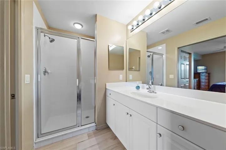 Bathroom featuring a spacious vanity with white cabinetry and a light-colored countertop