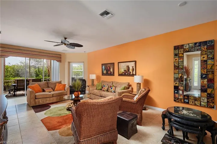 Living area with a ceiling fan and light tile patterned flooring