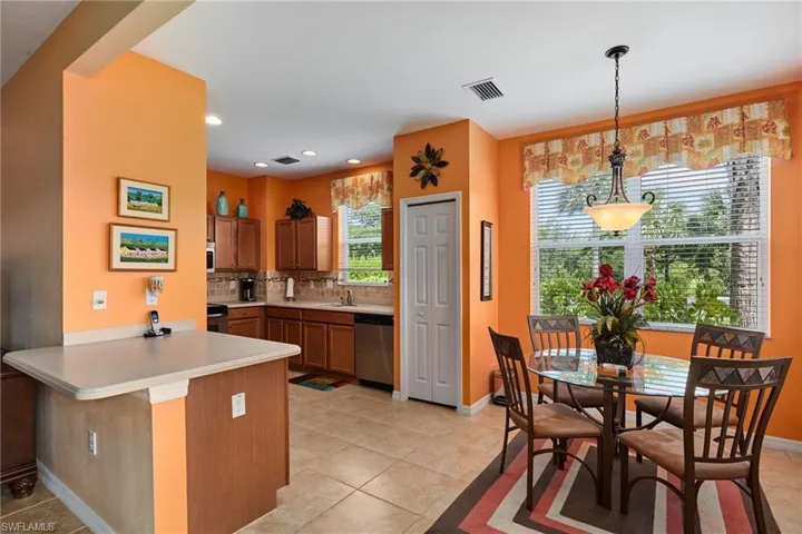 Kitchen with a peninsula, light tile patterned floors, tasteful backsplash, light countertops, and dishwasher