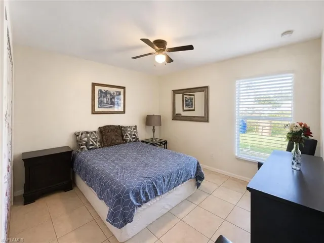 Tiled flooring, ceiling fan with integrated lighting, window with blinds, and neutral wall tones