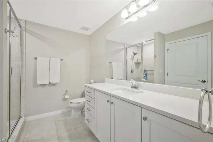Bathroom with vanity, a shower stall, and light tile patterned flooring