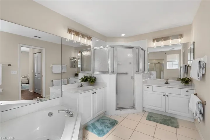 Bathroom with a shower stall, two vanities, and a sink