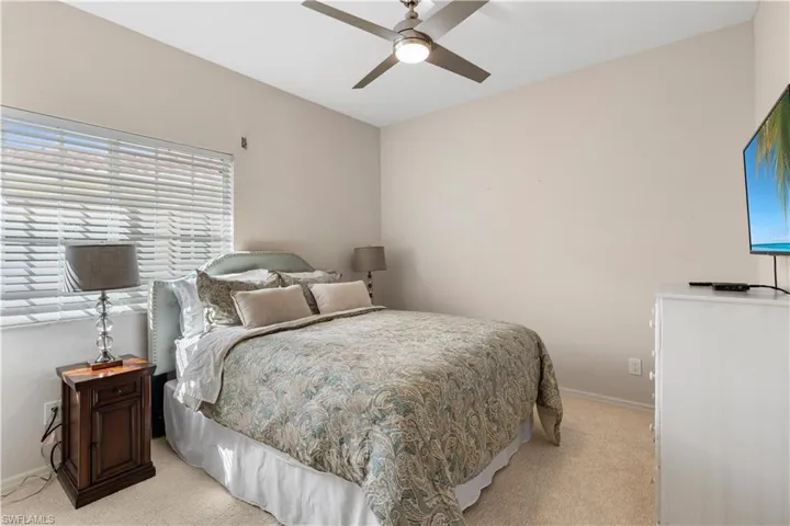 Bedroom featuring baseboards, light colored carpet, and ceiling fan