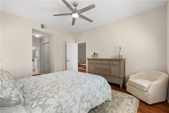 Bedroom featuring wood finished floors, visible vents, a closet, and ceiling fan