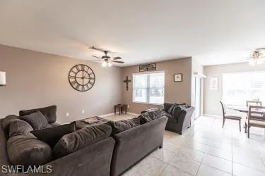 Living room with a ceiling fan and tile patterned flooring