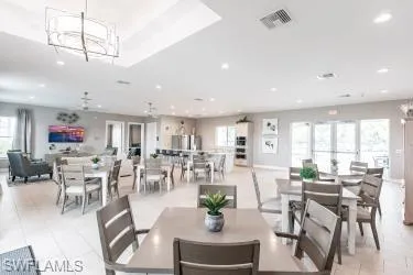 Dining space with a chandelier, light tile patterned floors, and recessed lighting