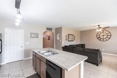 Kitchen with light countertops, pendant lighting, light tile patterned flooring, and open floor plan