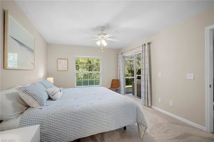 Carpeted bedroom featuring access to exterior and ceiling fan