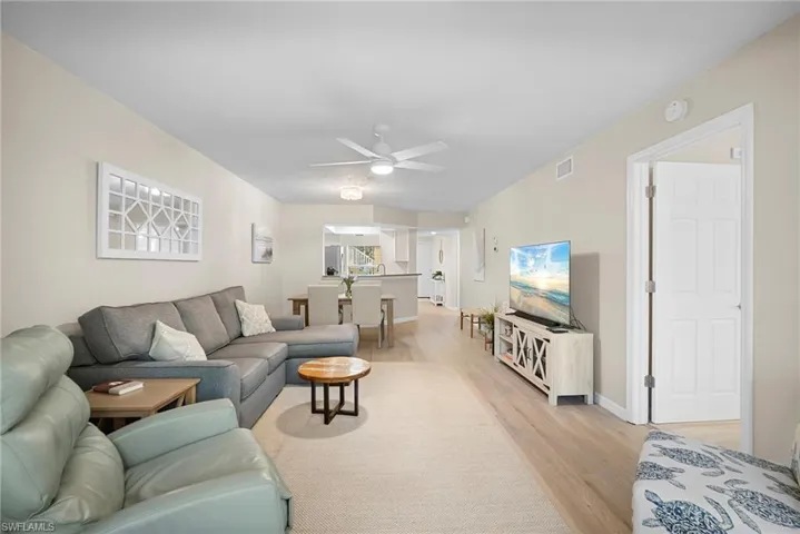 Living room with light wood finished floors and a ceiling fan