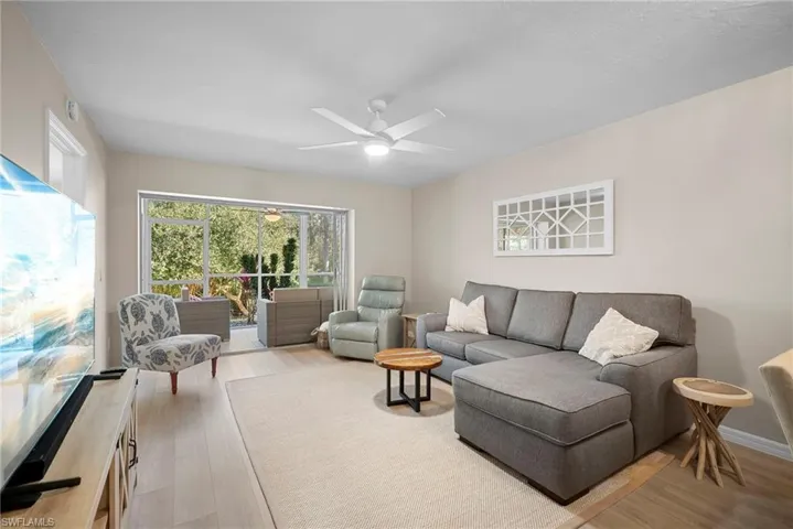 Living room with light wood-style flooring and ceiling fan