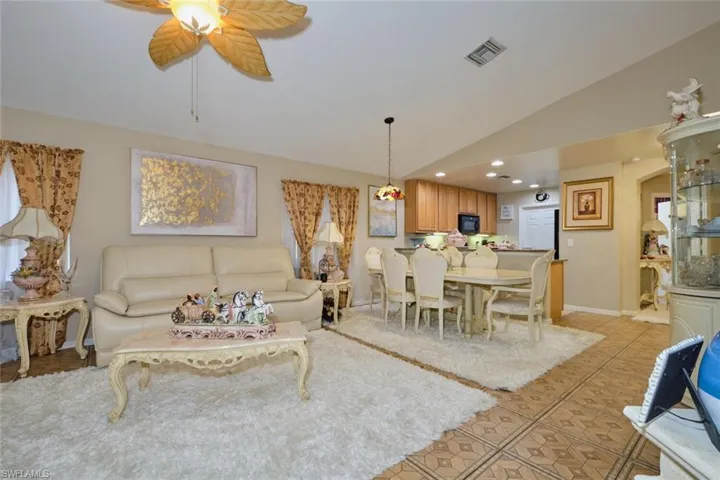 Tiled living room with vaulted ceiling and ceiling fan