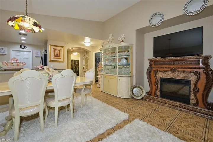 Tiled dining room with vaulted ceiling and a premium fireplace