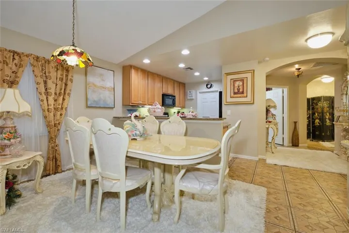 Dining area with light tile patterned flooring and lofted ceiling