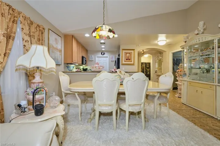 Tiled dining room featuring vaulted ceiling