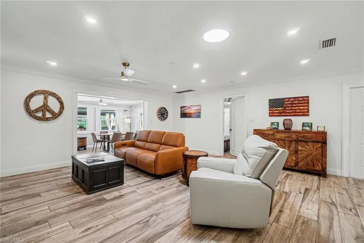 Open-concept living space with wood-finish flooring, recessed lighting, and a ceiling fan