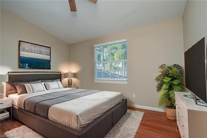 Bedroom featuring wood finished floors, ceiling fan, and lofted ceiling