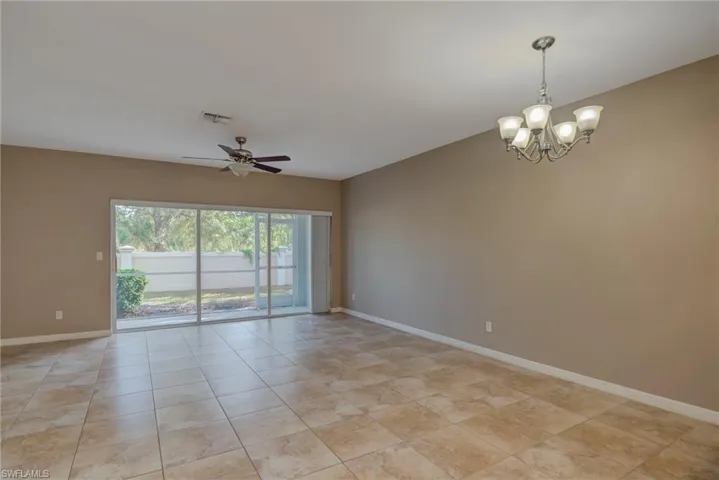 Unfurnished room with a chandelier, ceiling fan, and light tile patterned floors