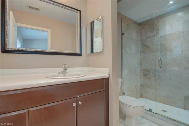 Full bathroom with a marble finish shower and vanity