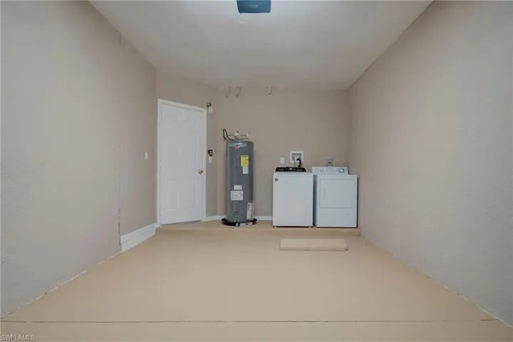 Washroom featuring independent washer and dryer and electric water heater