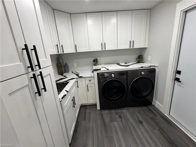 Laundry area with washer and dryer, dark wood-style floors, and cabinet space