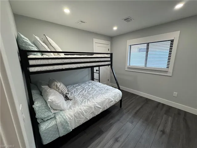 Bedroom with dark wood-style floors and recessed lighting