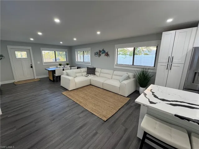 Living room with recessed lighting, plenty of natural light, and dark wood-style flooring