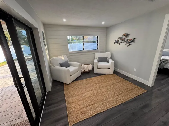 Sitting room with dark wood-style floors and recessed lighting