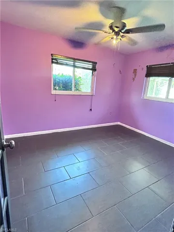 Tiled empty room with ceiling fan