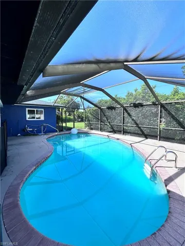 View of swimming pool with a patio and a lanai