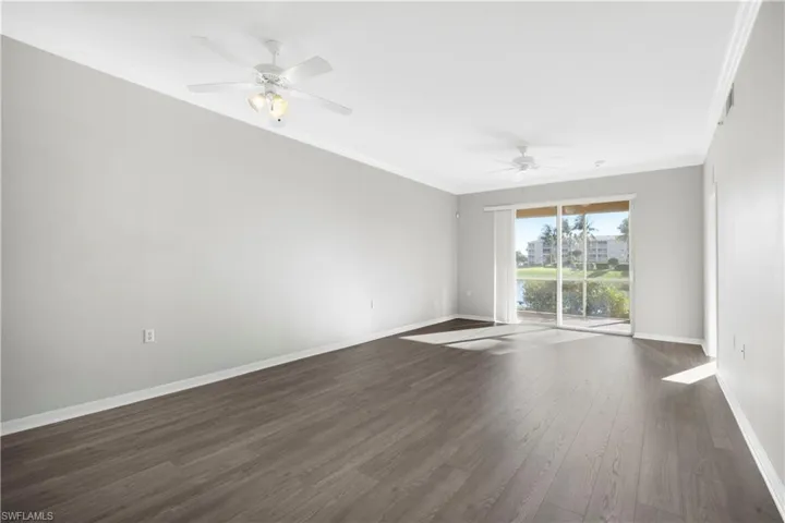 Unfurnished room featuring ornamental molding, dark wood finished floors, and a ceiling fan
