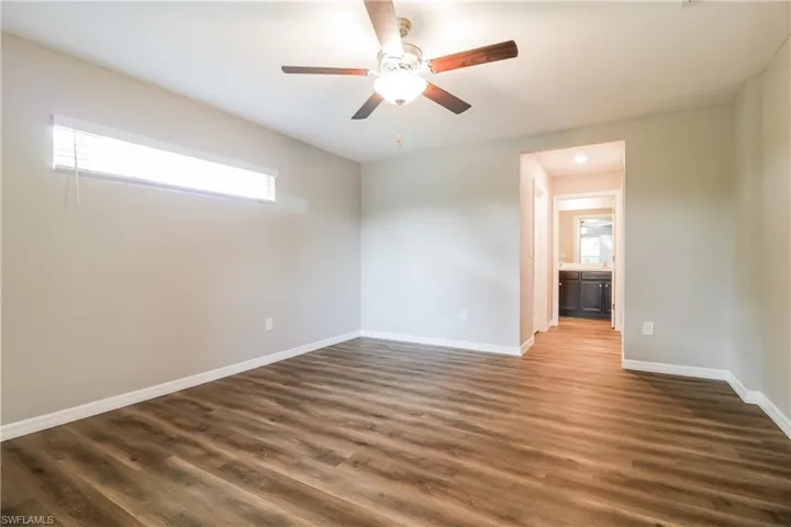 Spare room with a ceiling fan and dark wood-style floors