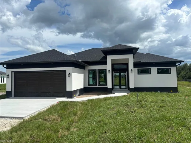 Prairie-style home with a garage and a front lawn