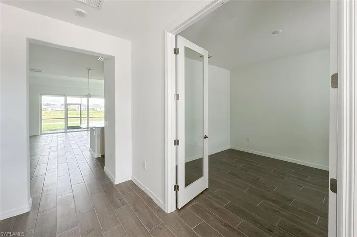 Corridor featuring baseboards and wood finish floors