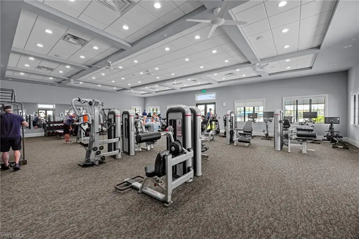 Gym with beamed ceiling, healthy amount of natural light, carpet floors, and coffered ceiling