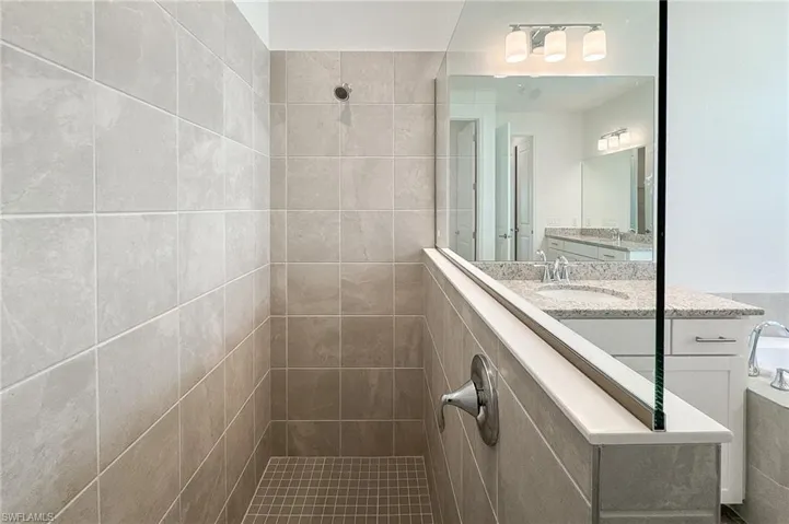 Full bath with a walk in shower, vanity, and a bath