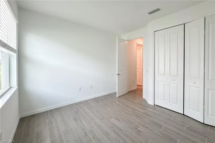 Unfurnished bedroom with wood tiled floors and a closet