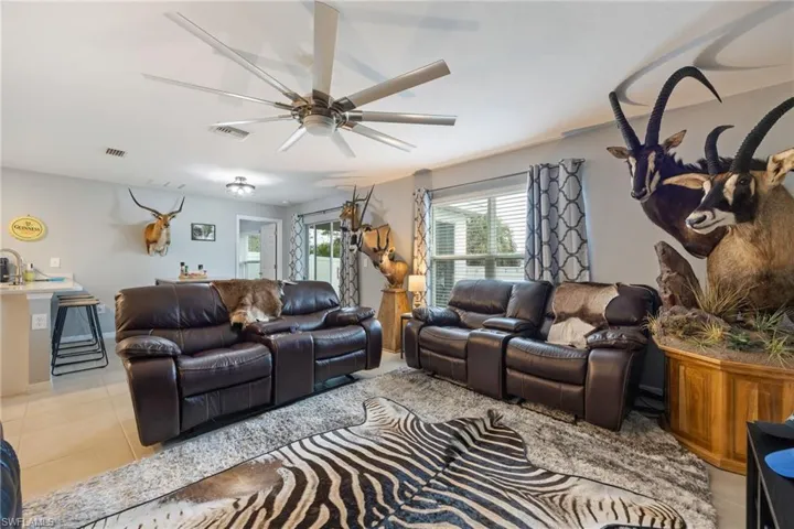 Living area featuring light tile patterned flooring and a ceiling fan