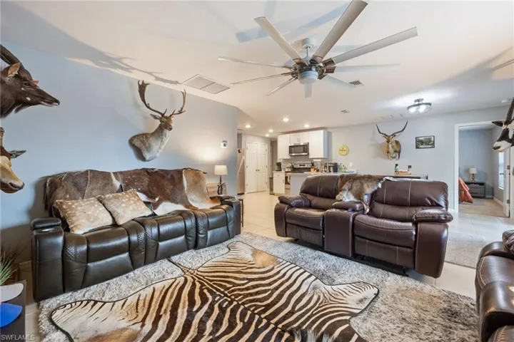 Living area with light tile patterned floors, recessed lighting, and ceiling fan