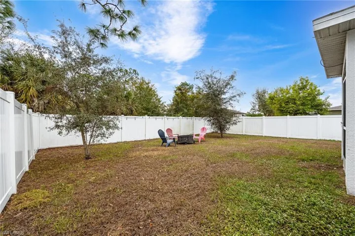 Fenced backyard with a fire pit