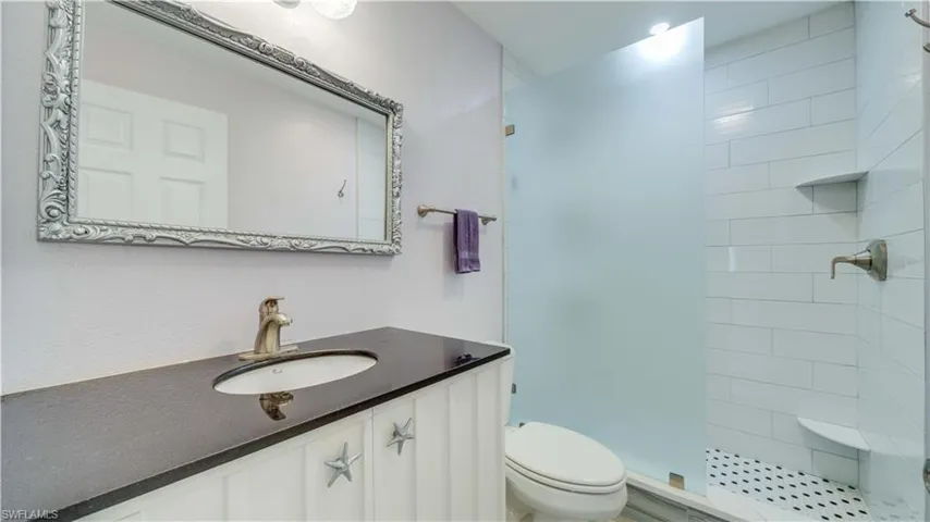 Full bathroom with vanity and a stall shower