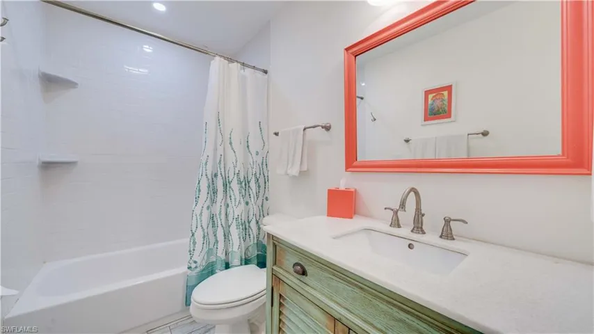 Full bath with shower / tub combo with curtain and vanity