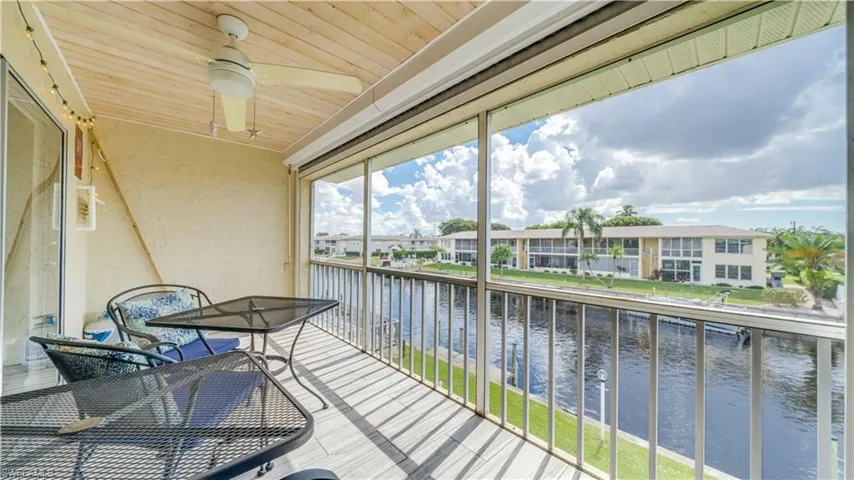 Balcony featuring a water view and a ceiling fan