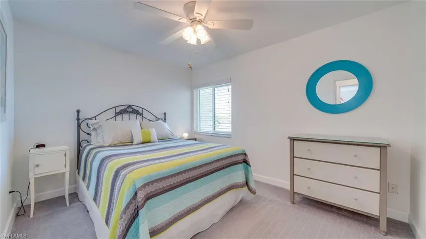 Bedroom with light carpet and a ceiling fan