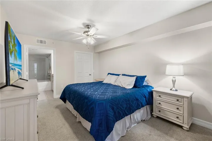 Primary bedroom with ensuite bath, and ceiling fan.