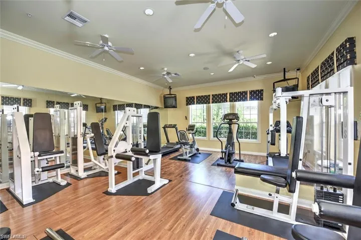 Workout area featuring ornamental molding and hardwood / wood-style floors