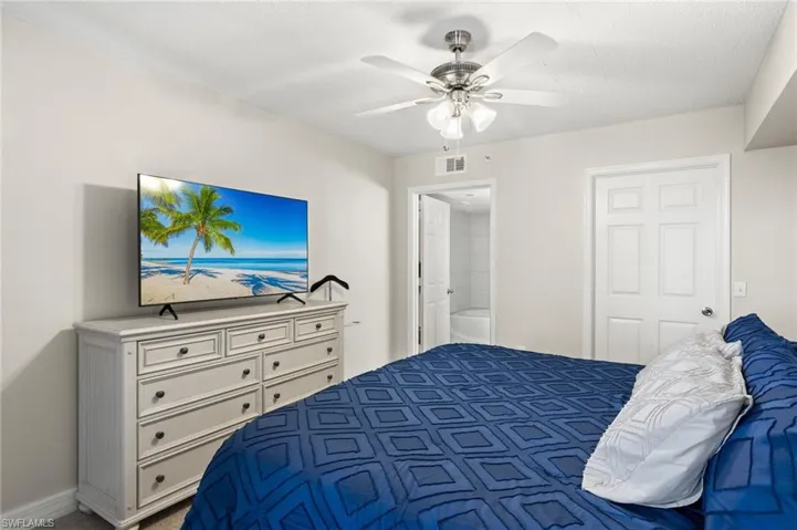 Primary bedroom with ensuite bath, and ceiling fan.