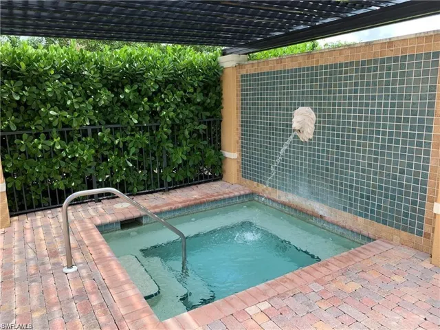View of swimming pool with a pergola and an in ground hot tub