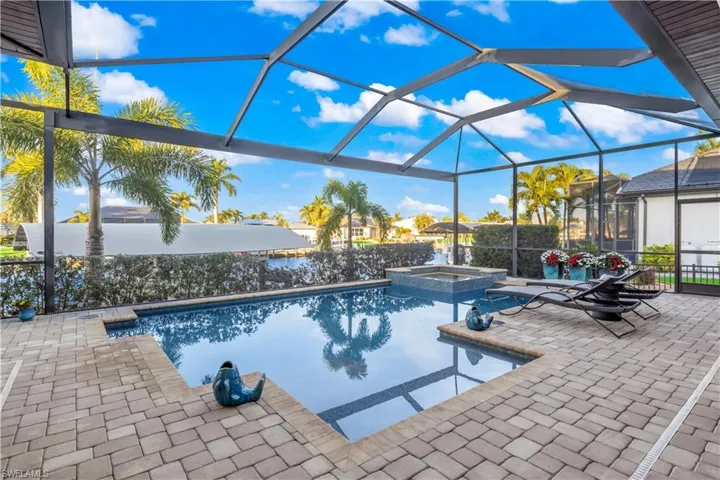 Inviting pool and spa retreat with a sun deck and lounge areas, offering a seamless blend of relaxation and luxury waterfront living.