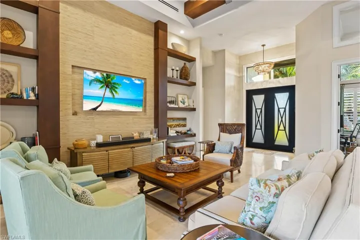 Custom living area, where the TV wall panel stands as a sophisticated focal point in a tastefully designed space.  Tall ceilings, linear ac vents - this home is customized and timeless!
