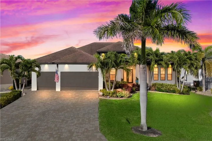 Welcoming façade showcasing custom detailing, three-car garage, and serene street presence.  Lush and mature landscaping and so many upgrades in this magnificent home!